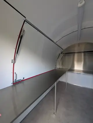 Plan de travail inox à l'intérieur de la remorque, côté volet de service