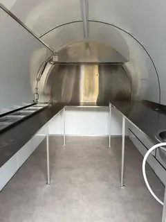 Vue intérieure de la remorque coloris beige, plan de travail et hotte